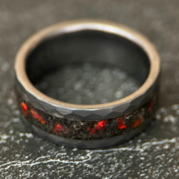 Meteorite ring with red opal inlay and a hammered tungsten comfort core.