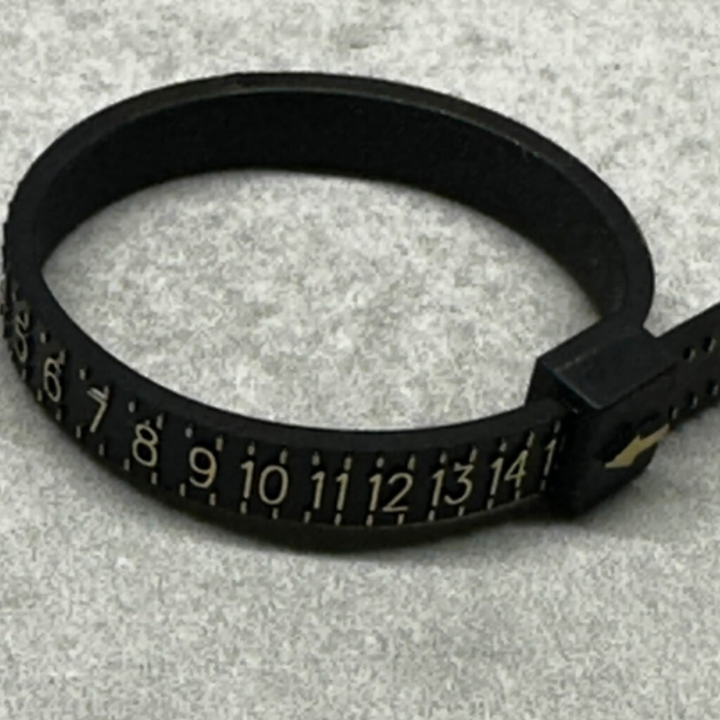 How to measure your ring size. Picture shows a plastic ring sizer.