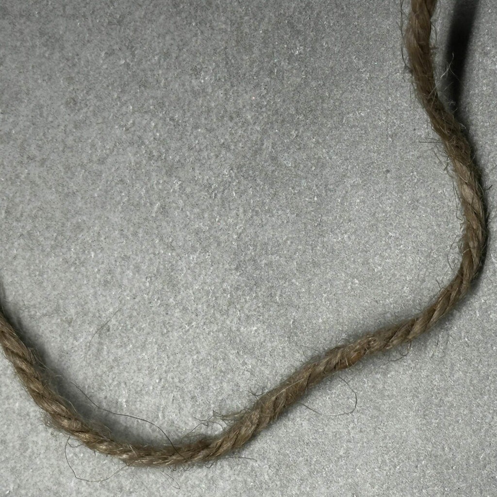 Sturdy string shown against a tile background used to measure a person's ring size.