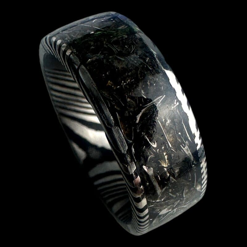 Damascus steel ring with Pershing tank inlay on a black background.