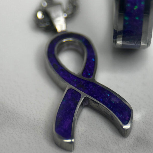 Cancer awareness ribbon in purple with purple cancer support ring.