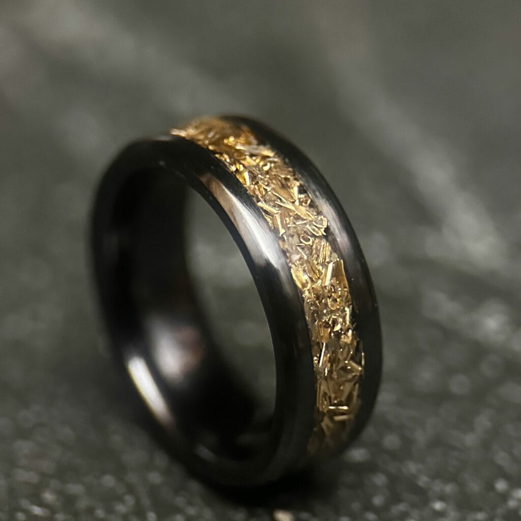 Black ceramic ring with tank inlay on dark background