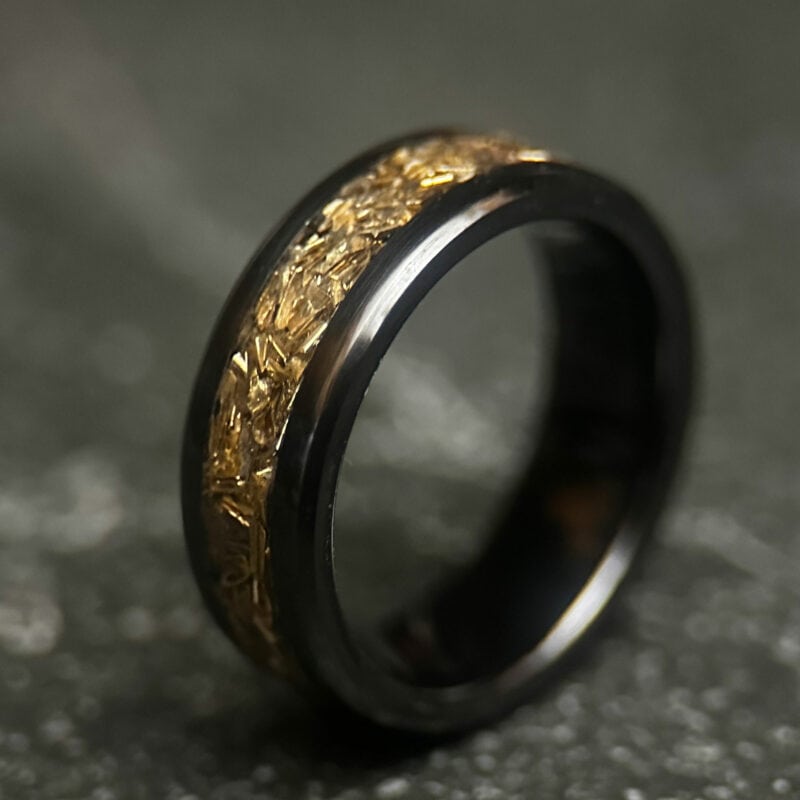 Black ceramic ring with tank inlay on dark background