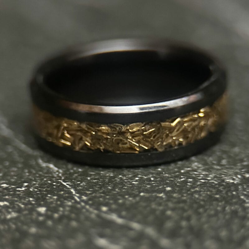 Black ceramic ring with tank inlay on dark background