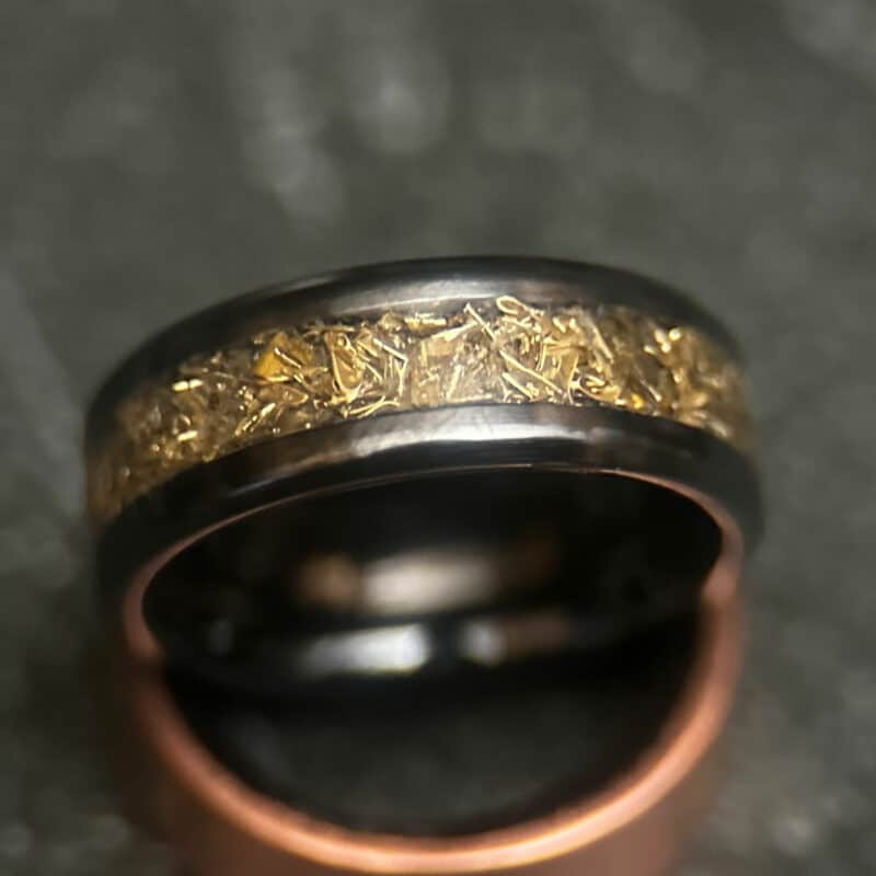 Black ceramic ring with tank inlay on dark background