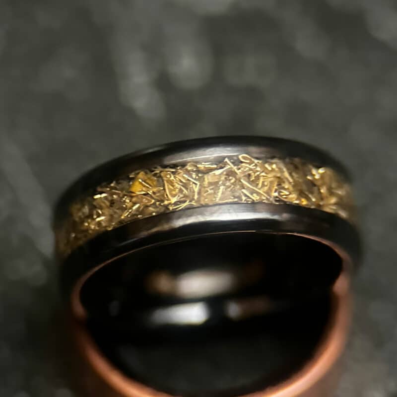 Black ceramic ring with tank inlay on dark background