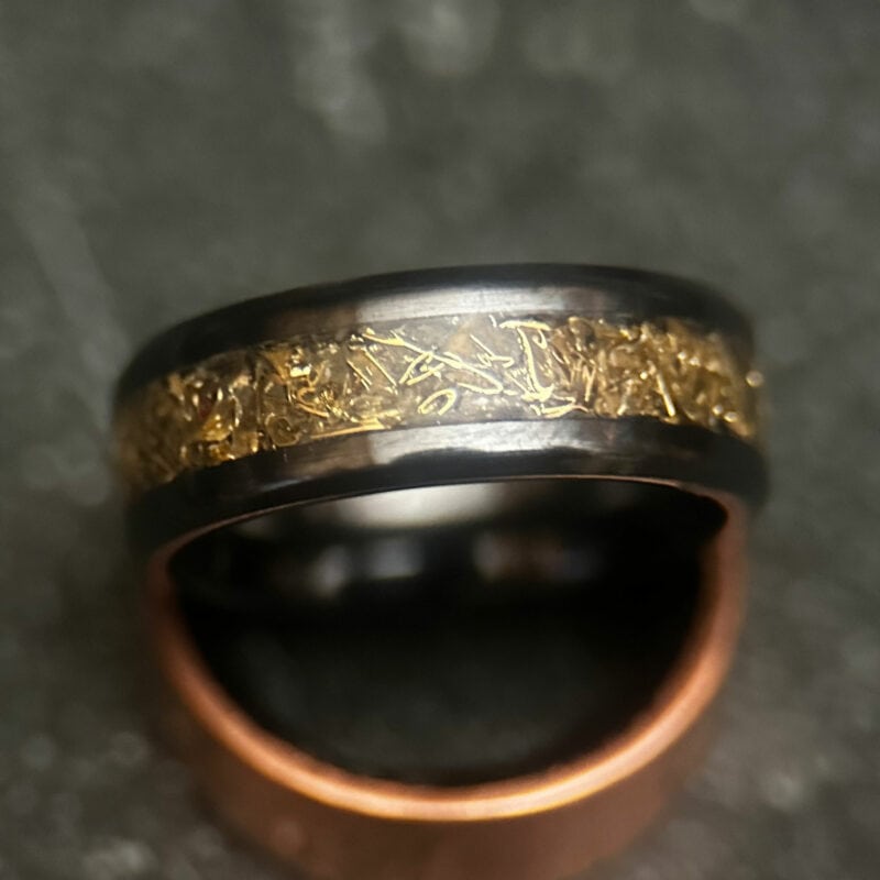 Black ceramic ring with tank inlay on dark background