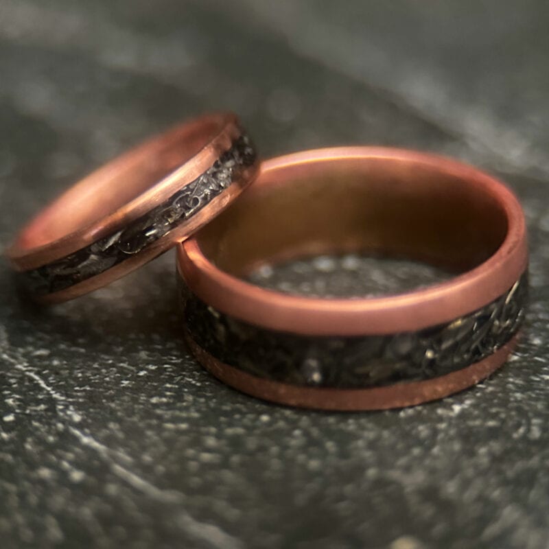 Two Copper rings with tank scrap on a dark background