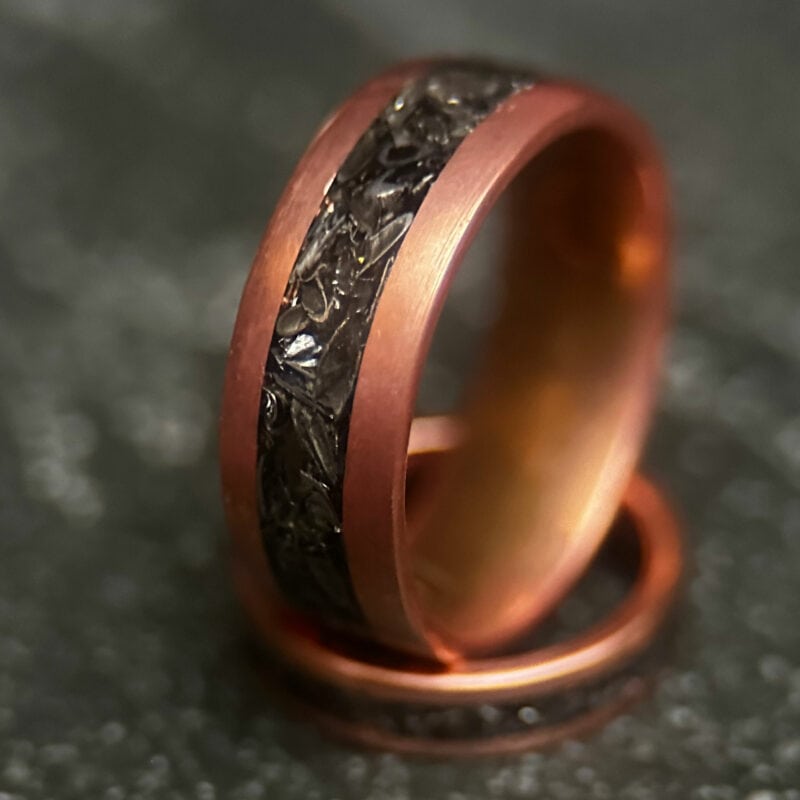 Copper ring with tank scrap on a dark background