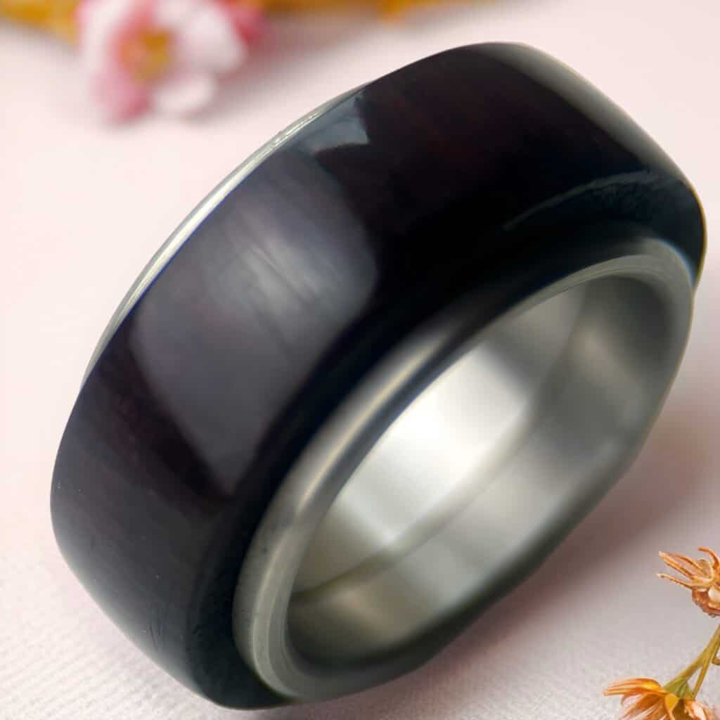 Purpleheart fidget ring on neutral background with flowers.