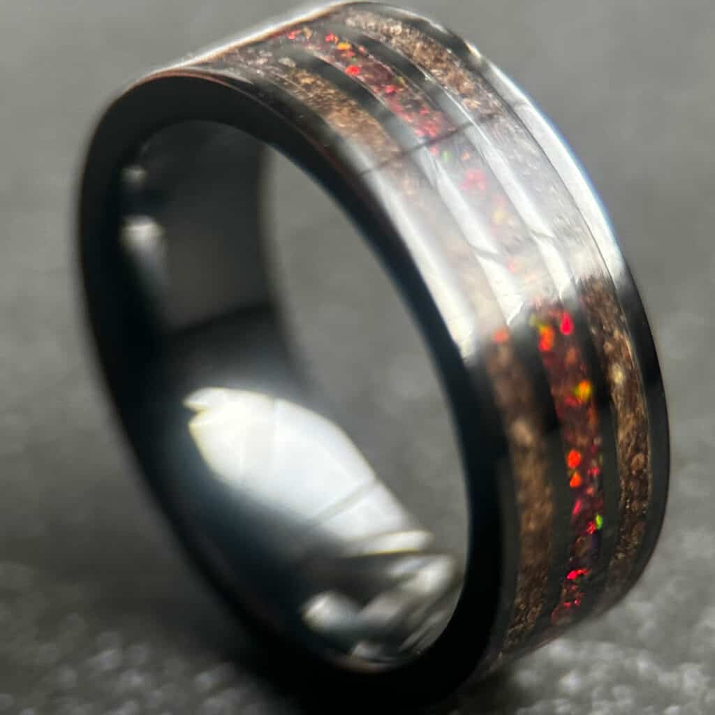 T-rex fossil ring with two columns of brown t-rex fossil, black ceramic separators, and a center column of magma opal.