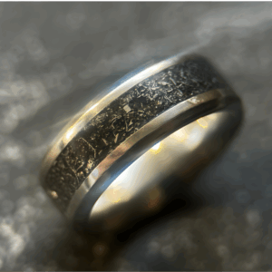 Mens wedding meteorite ring set on dark background.