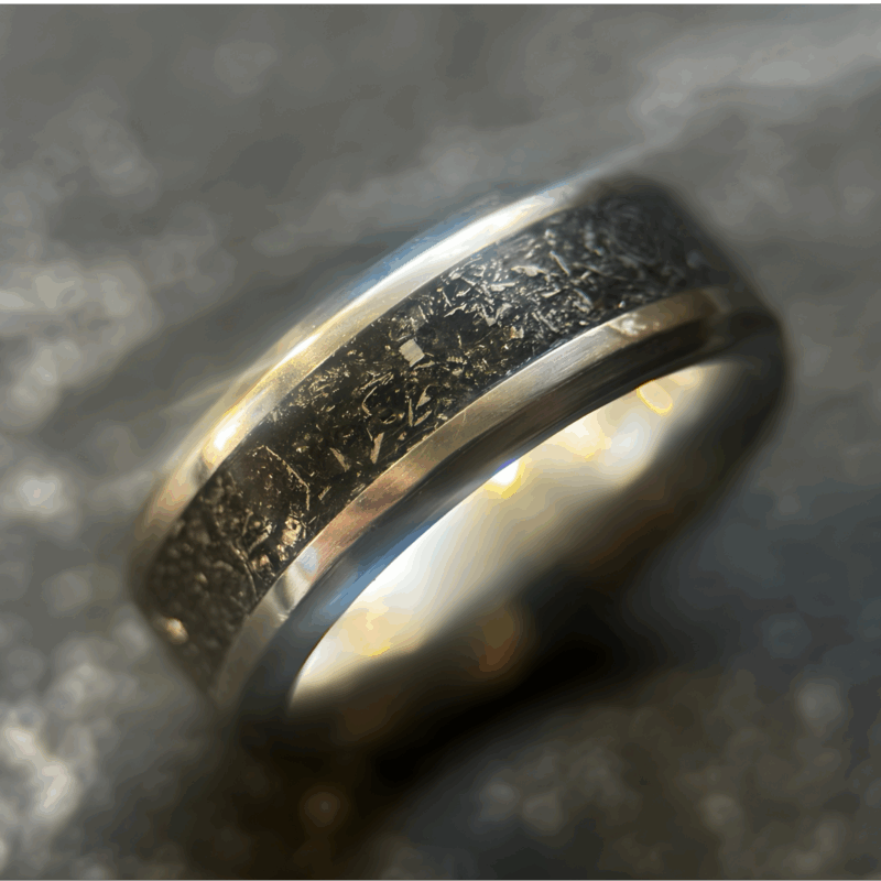 Mens wedding meteorite ring set on dark background.