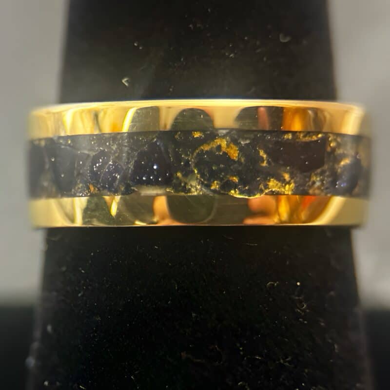 Nordic gold ring with blue gold stone inlay on a ring stand.