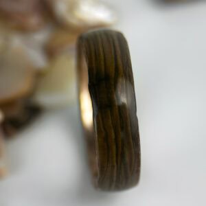 driftwood copper ring with shells in background.