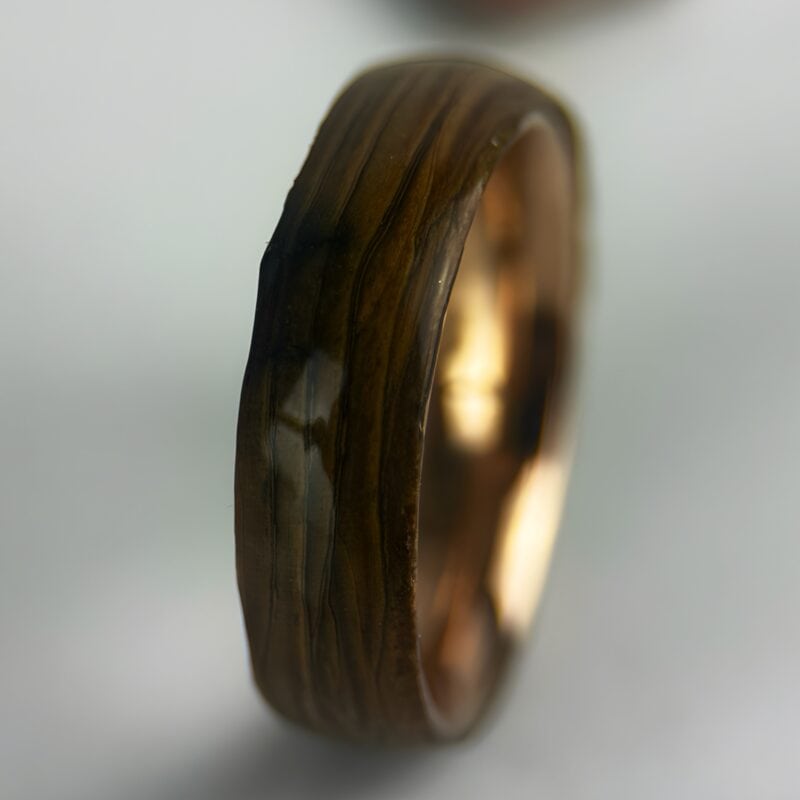 Driftwood ring with copper core on neutral background.