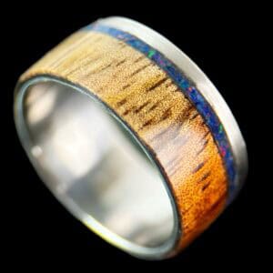 koa wood ring, live edge with stainless steel edge, stainless steel core, and opal inlay.