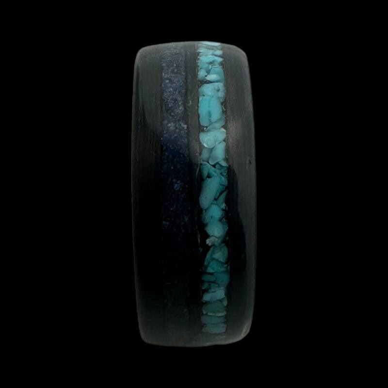 Pregnancy and infant loss birthstone ring shown with blue powder and turquoise. Set in black carbon fiber ring.