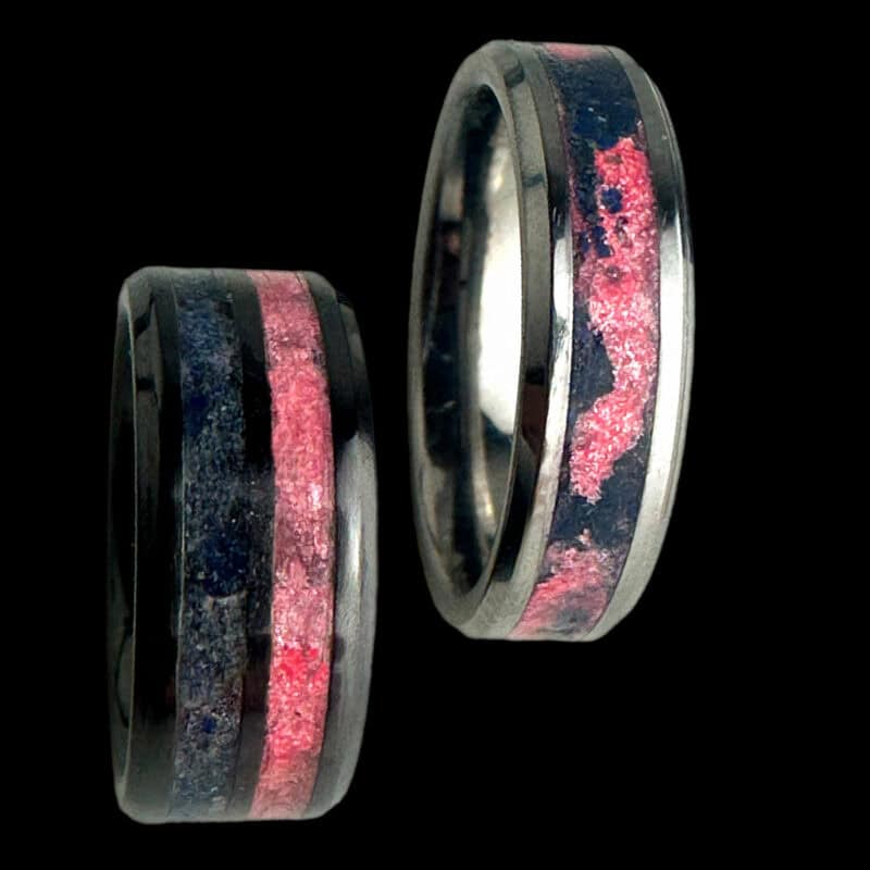 Pregnancy and infant loss awareness rings. Black ceramic with blue and pink inlays. Tungsten ring with swirled blue and pink inlay in single channel.
