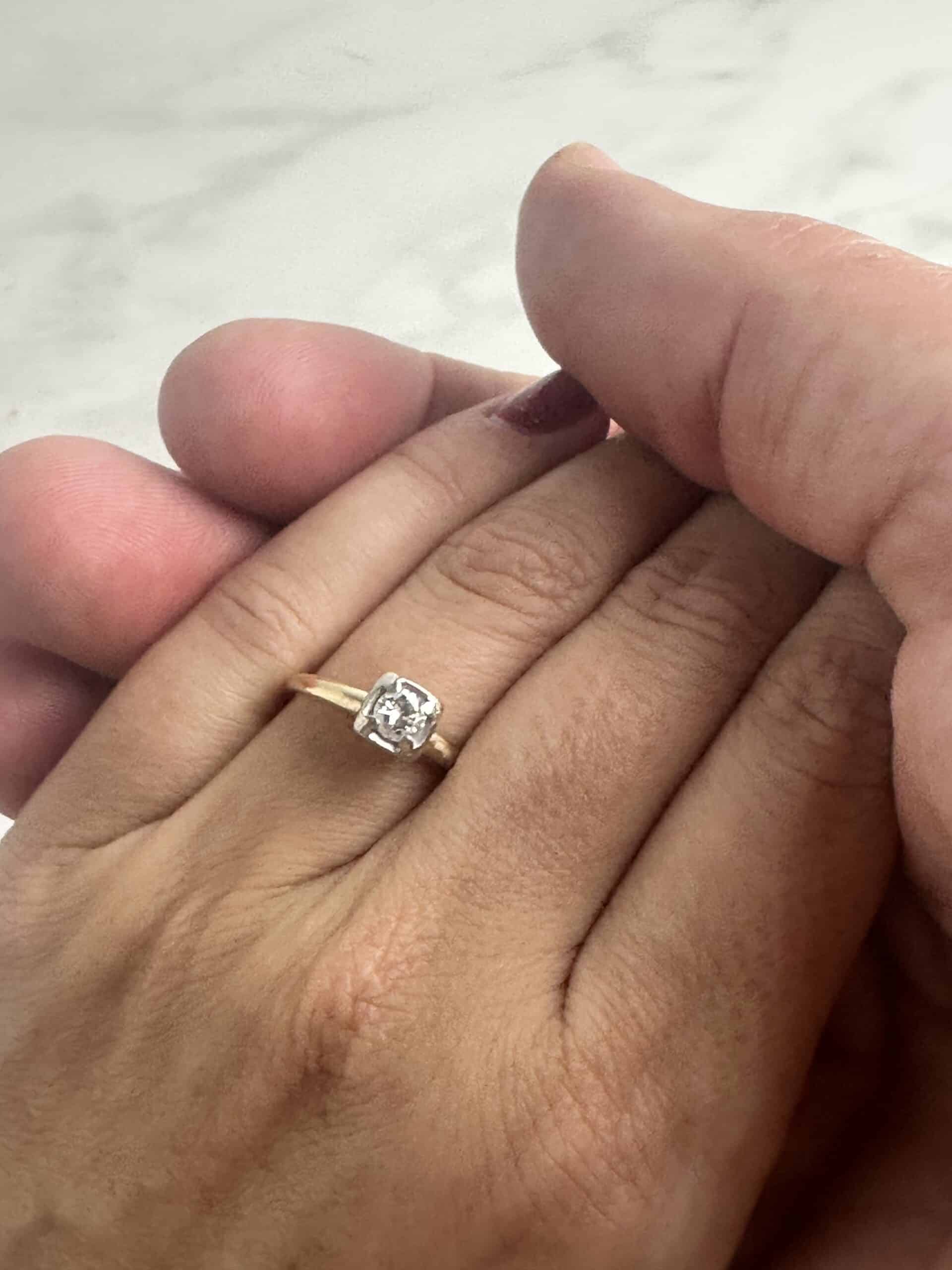 What to do after engagement pic. Woman's hand with a gold diamond ring on the finger.