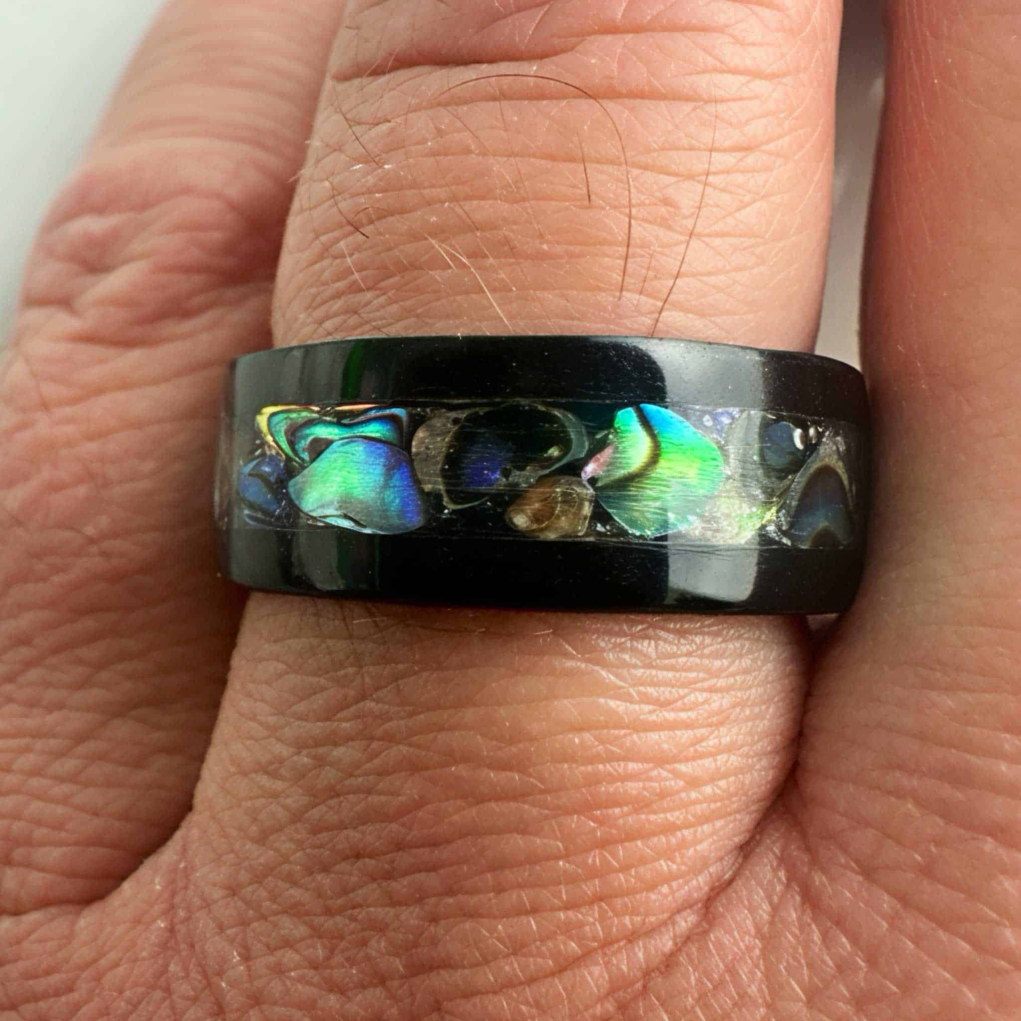 Blackwood ring with abalone inlay and stainless steel comfort core shown a man's finger.